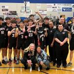 The JDHS Crimson Bears basketball team poses for a victory photo after the net cutting ceremony on Saturday. The Bears beat Ketchikan High School in a second tournament game, securing the teams spot at state. (Jonson Kuhn / Juneau Empire)