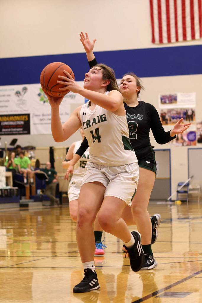 Craig senior Alissa Durgan (14) gets ready for a shot near the basket while Haines senior Malia Jorgenson-Geise (12) tries to chase her down. (Ben Hohenstatt / Juneau Empire)