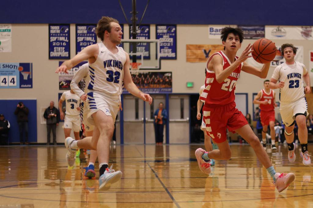 Wrangell sophomore Kyan Stead (20) races down the court pursued by Petersburg senior Jack Engell (32). (Ben Hohenstatt / Juneau Empire)