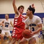 Wrangell senior Ethan Blatchley (12) defends while Petersburg sophomore Rik Cumps gets ready to make a move for an up-and-under score. (Ben Hohenstatt / Juneau Empire)