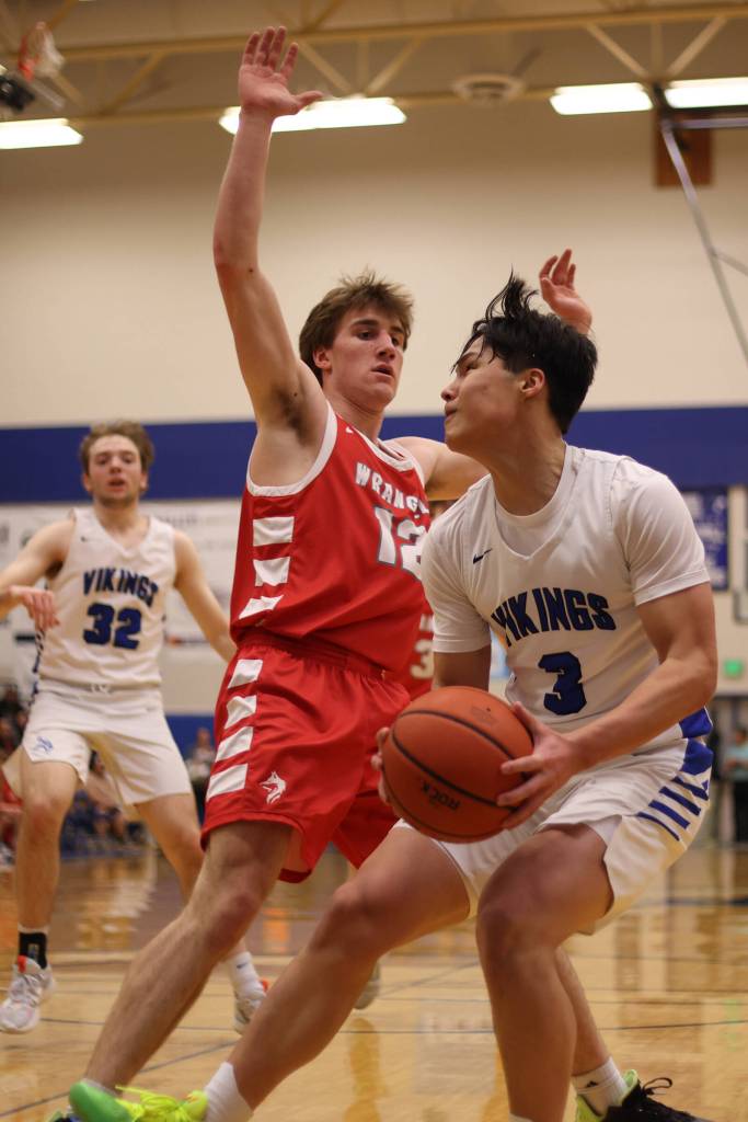 Wrangell senior Ethan Blatchley (12) defends while Petersburg sophomore Rik Cumps gets ready to make a move for an up-and-under score. (Ben Hohenstatt / Juneau Empire)