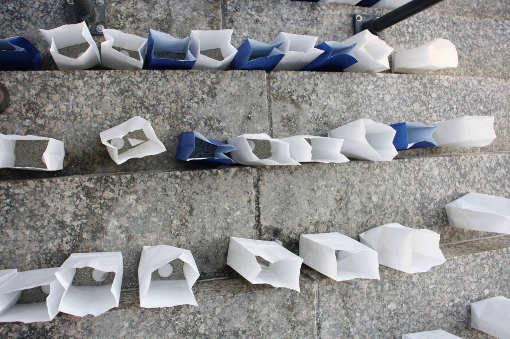 Unlit candles inside paper bags are placed in groups on the steps of the Alaska State Capitol, each representing a resident who committed suicide in 2021. The bags for the 220 candles were color-coded, with blue bags representing military service members who died. (Mark Sabbatini / Juneau Empire)
