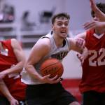 Juneaus Kaleb Tompkins cuts through Kake defenders on his way to the hoop in a Sunday win in the first B Bracket game of the Juneau Lions Club 74th Gold Medal Basketball Tournament. (Ben Hohenstatt / Juneau Empire)