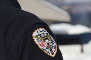 A police officer stands on duty in early March. The City and Borough of Juneau announced Monday incoming Juneau Police Department officers will now be offered a hiring bonus of up to $30,000 in exchange for a four-year commitment to the department. (Clarise Larson / Juneau Empire File)