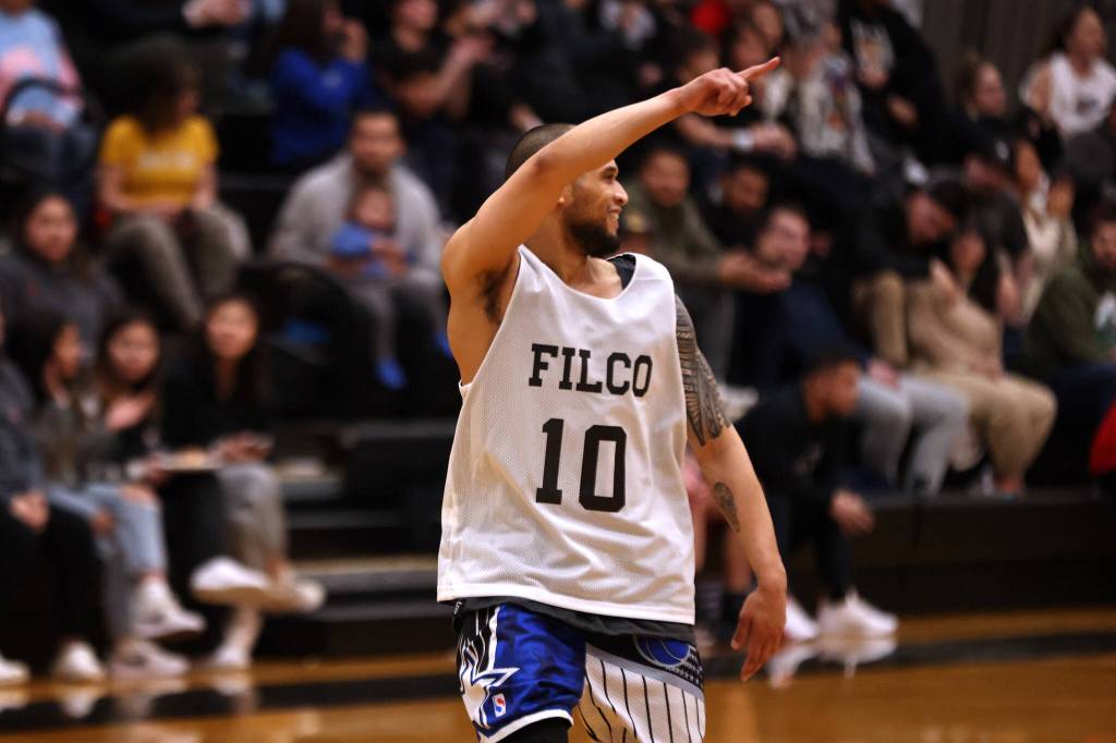 Filcoms Larry Cooper points to the crowd in celebration after sinking a 3-pointer. Cooper poured in 36 points in his teams 87-66 win against Hoonah, including six 3-pointers. (Ben Hohenstatt / Juneau Empire)