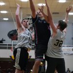Hoonahs Travis Dybdahl scores between Filcoms Tom Gisler (13) and Charlie Herrington (32) during C Bracket action in the Gold Medal Basketball Tournament, Monday, March 20, at Juneau-Douglas High School: Yadaa.at Kalé. (Klas Stolpe / For the Juneau Empire)