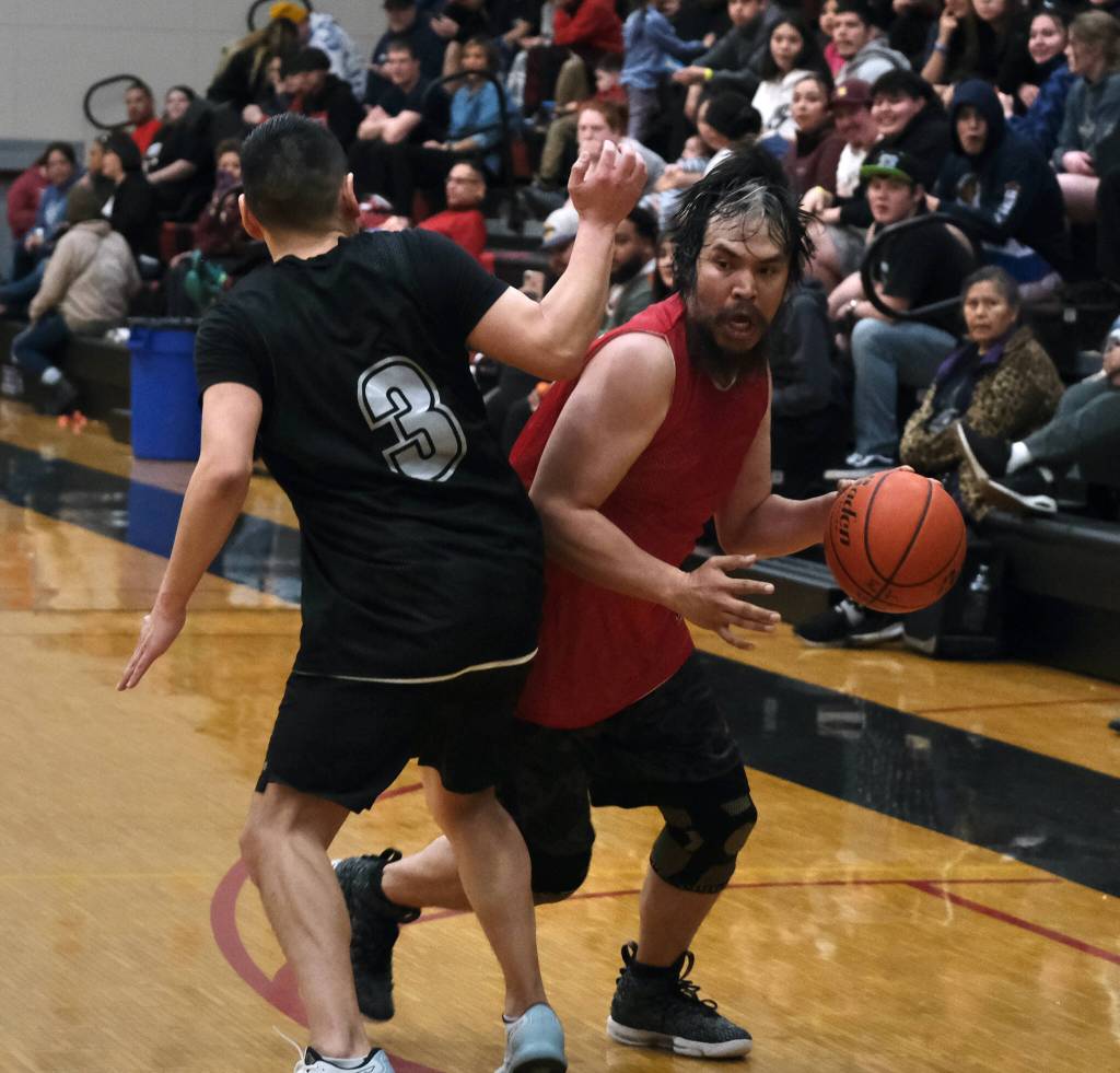 Kakes Kelly Brown dribbles around Angoons Frank Lane (3) during C Bracket action in the Gold Medal tournament, Tuesday, March 21, at Juneau-Douglas High School: Yadaa.at Kalé. (Klas Stolpe / For the Juneau Empire)