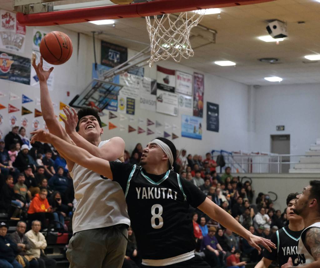 Angoons Anthony Snow shoots against Yakutats Robert Sensmeier (8) during the Gold Medal tournament, Tuesday, March 21, at Juneau-Douglas High School: Yadaa.at Kalé. (Klas Stolpe / For the Juneau Empire)