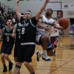 Angoons JJ Jack Nixon shoots against Yakutats Robert Sensmeier (8) during the Gold Medal Basketball Tournament, Tuesday, March 21, at Juneau-Douglas High School: Yadaa.at Kalé. (Klas Stolpe / For the Juneau Empire)