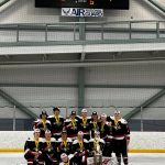 Juneau Capitals 18-and-under, Tier A hockey squad gather for a team photo under the scoreboard reflecting a 4-3, triple overtime victory over the Alaska Avalanche. (Courtesy Photo / Kristin Bartlett)