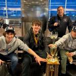 Coach Jason Kohlhase joins players, from left, Lake Bartlett, Brandon Campbell and son, Karter Kohlhase, around the team's 18-and-Under, Tier A hockey state championship trophy. Campbell ended the triple overtime marathon by ramming home a rebound off teammate Kohlhase's face off shot.
 (Courtesy Photo / Kristin Bartlett)