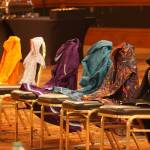 Kuspuks of varying colors displayed at a tribal consultation meeting in Anchorage on Sept. 21 represent Indigenous victims of violence. From left, the colors are red for Missing and Murdered Indigenous Women, orange for victims of boarding schools, the baby kuspuk for children who will never be born, purple for victims of domestic violence, turquoise for victims of sexual assault, multicolor for LGBTQ victims and black for men who are victims. The kuspuks were arrayed at the Justice Departments annual tribal consultation conference required under the Violence Against Woman Act. In testimony Wednesday to the state House Tribal Affairs Special Committee, members of a working group listed several practical steps they said could improve safety of Indigenous people. (Photo by Yereth Rosen/Alaska Beacon)