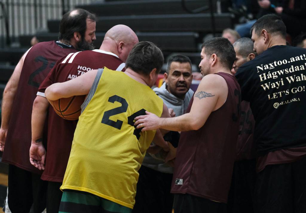 Sitkas Steve Edenshaw (24) infiltrates the Hoonah huddle prior to tip off of their game during Thursday action at the Juneau Lions Club 74th Gold Medal Basketball Tournament at Juneau-Douglas High School: Yadaa.at Kalé. (Klas Stolpe/For the Juneau Empire)