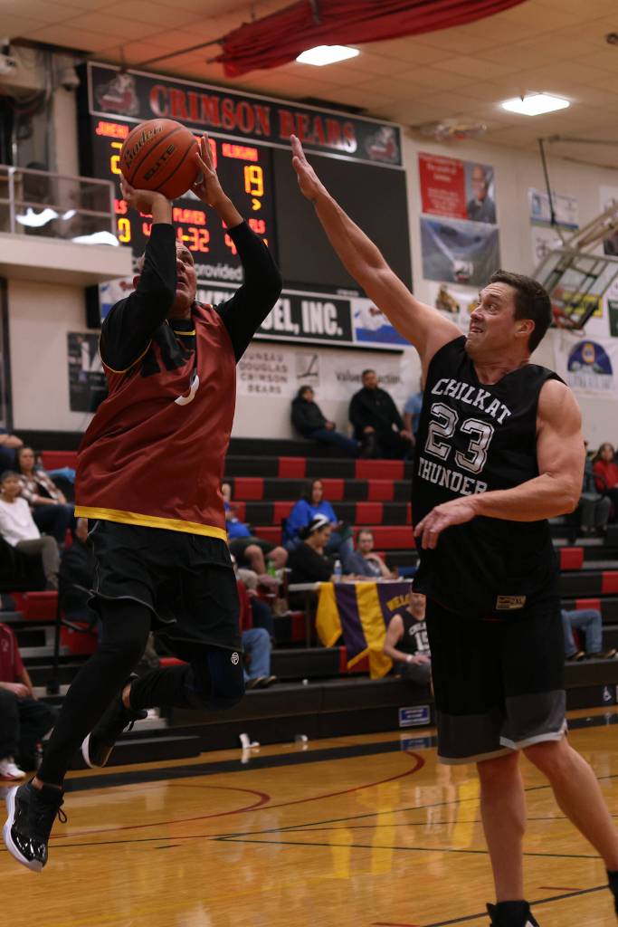 Juneaus James Mercer (6) shoots while defended by Klukwans Russ Stevens in the second quarter of a 48-39 win for Juneau in the Masters Bracket. (Ben Hohenstatt / Juneau Empire)