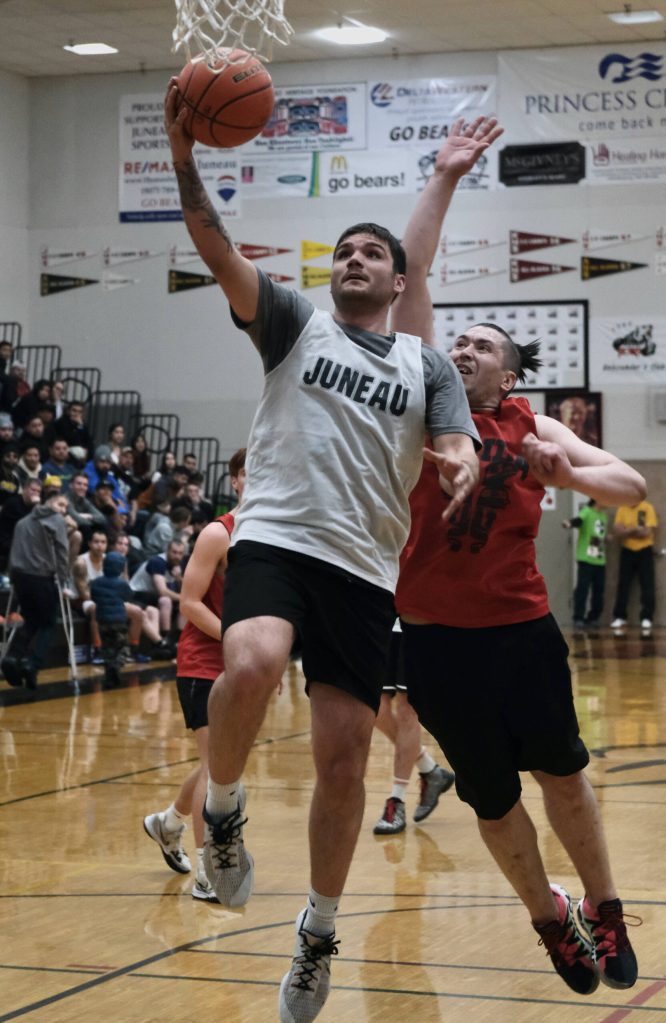 Juneaus Stewart Conn scores past Hydaburgs George Peratrovich during Thursdays B Bracket semifinal in the Juneau Lions Club 74th Gold Medal Basketball Tournament at Juneau-Douglas High School: Yadaa.at Kalé. (Klas Stolpe/For the Juneau Empire)