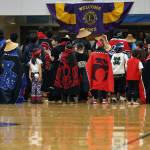 Dancers, including the Eagle Raven Dancers, Wooshji.een and students in the TCLL Program, stand in between songs Thursday evening during a performance ahead of a Gold Medal Basketball Tournament game between Juneau and Hydaburg. (Ben Hohenstatt / Juneau Empire)
