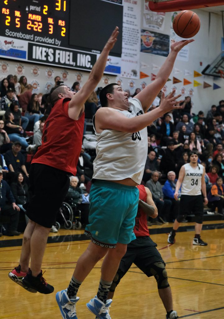 Angoons Kendrick Payton scores as Hydaburgs George Peratrovich defends during Saturdays B Bracket double-overtime elimination game. (Klas Stolpe/For the Juneau Empire)