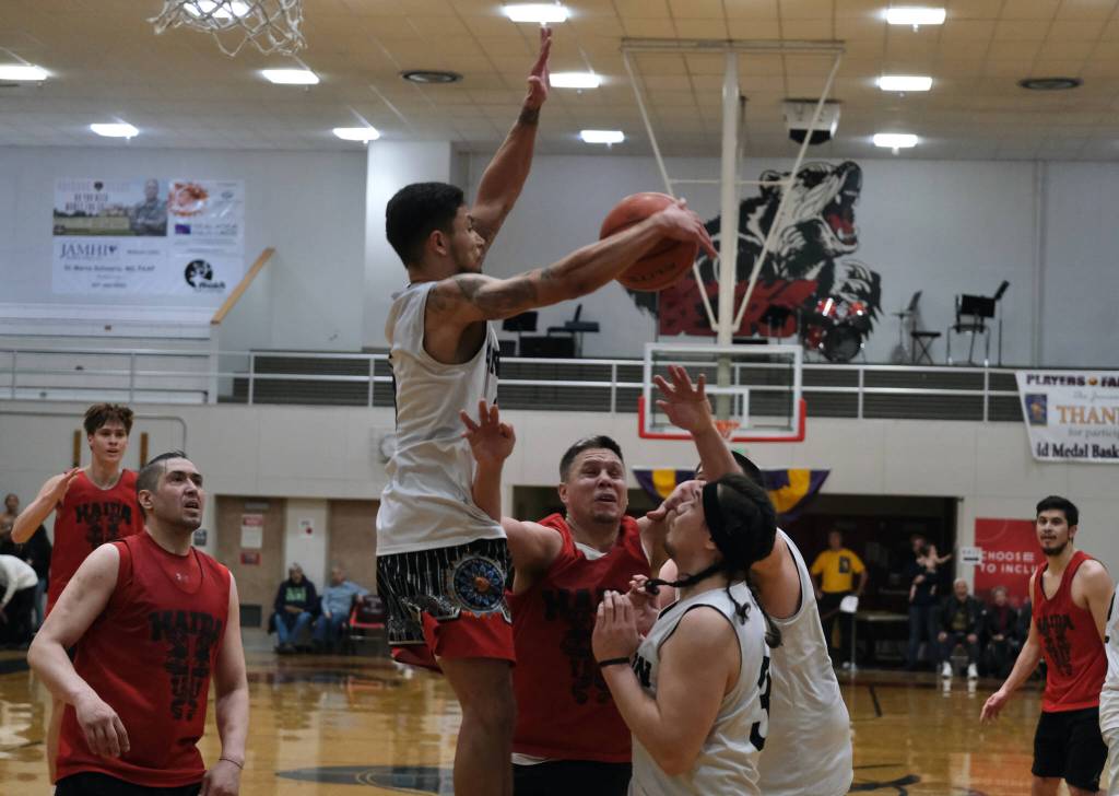 Angoons Kendrick Payton scores as Hydaburgs George Peratrovich defends during Saturdays B Bracket double-overtime elimination game. (Klas Stolpe/For the Juneau Empire)