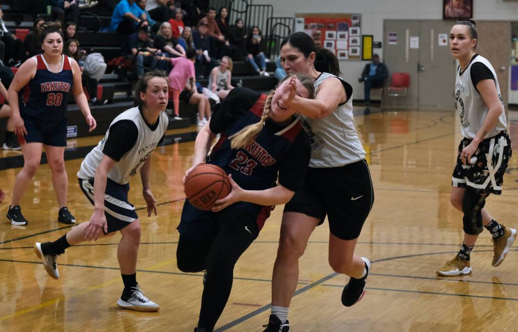 Yakutats Janie Jensen (23) is fouled by POWs Tina Steffen during the Gold Medal Basketball Tournament, Saturday, March 25, at Juneau-Douglas High School: Yadaa.at Kalé. (Klas Stolpe/For the Juneau Empire)