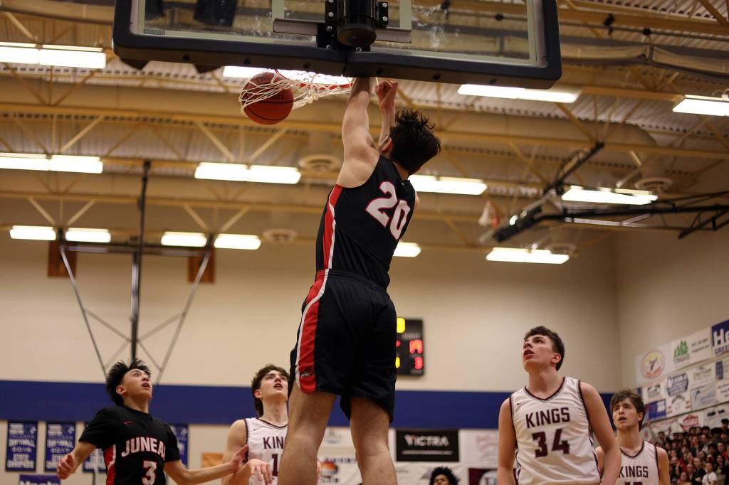 JDHS senior Orion Dybdahl finishes a dunk with authority as teammate Alwen Carrillo (3) and Kayhis, Marcus Stockhausen (34) and Andrew Kleinschmidt (13) look on. Dybdahl earned third team all-state honors with his play this season. (Ben Hohenstatt / Juneau Empire)