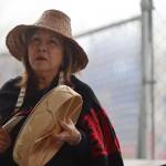 Nancy Barnes of the Chugach Villages leads people gathered at Marine Park on Friday through songs and prayers as part of the blessing ceremony for the Kootéeyaa Deiyí (Totem Pole Trail) that will run along the downtown Juneau waterfront. (Jonson Kuhn / Juneau Empire)