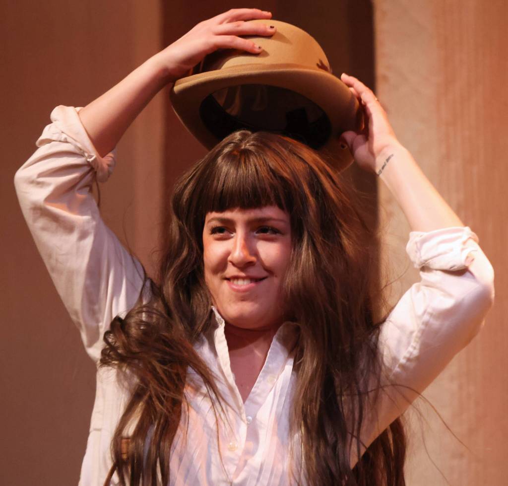 Jo March (Ema Zivkovic) places a recently swiped hat upon their head during rehearsal for Little Women, which opens Friday. (Ben Hohenstatt / Juneau Empire)