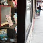 A collection of books including LGBTQ-friendly titles are displayed in the storefront window of Alaska Robotics in downtown Juneau on Tuesday. The store, which featured books and cards illustrated by local artist Mitchell Watley, removed them following his arrest Sunday for allegedly placing transphobic notes threatening violence against children at locations around town. (Mark Sabbatini / Juneau Empire)