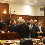 Members of the House majority and House Minority Leader Calvin Schrage, I-Anchorage, at far right, cluster around the podium of House Speaker Cathy Tilton during a break in Wednesdays floor session that featured an hours-long standoff involving an increase in education funding. (Mark Sabbatini / Juneau Empire)