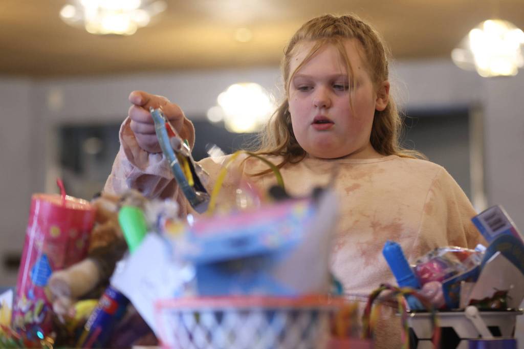 Sadie Kephart, 9, looks for a basket with room for Spider-Man decorations Saturday. As the youngest person helping the Women of the Moose pack Easter baskets for youths at AWARE shelters, Kephart frequently weighed in on what treat would be most appreciated by a child of a certain age. (Ben Hohenstatt / Juneau Empire)