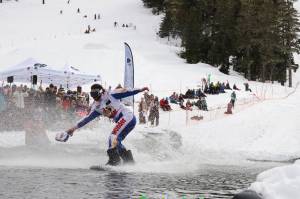 A snowboarder stays afloat on the skim pond at Eaglecrest Ski Area as they partake in the return of the Slush Cup Saturday afternoon. (Clarise Larson / Juneau Empire)