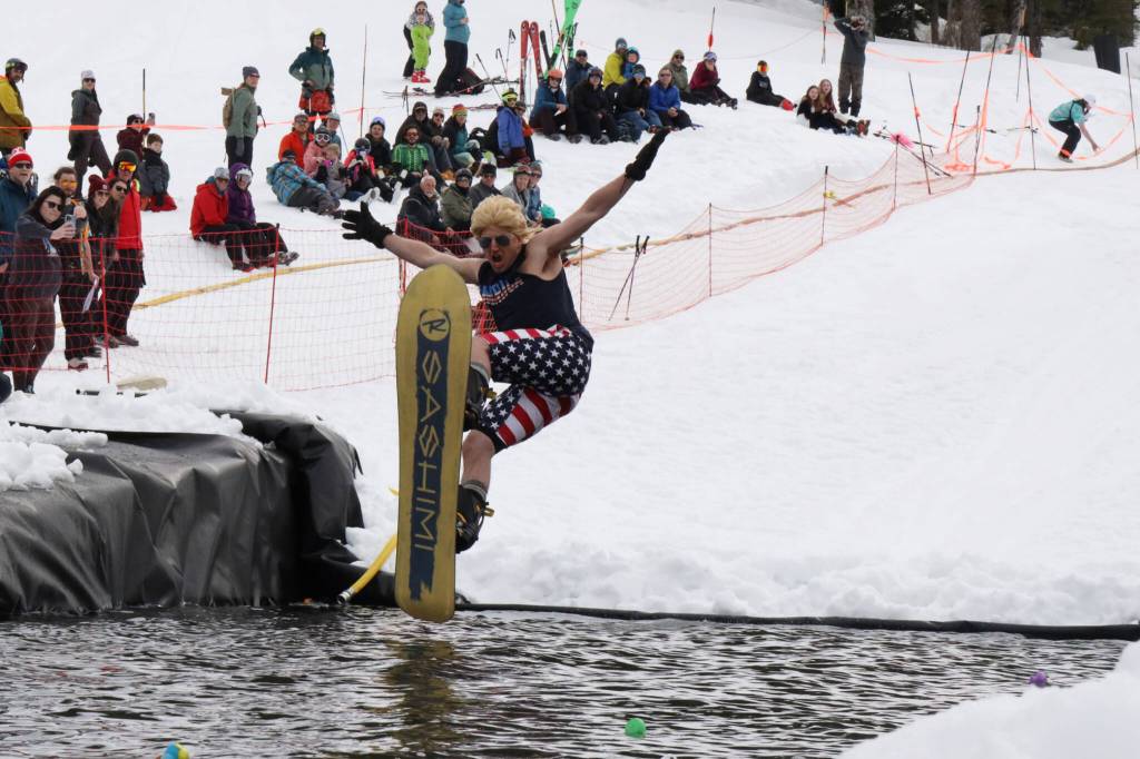 A snowboarder leaps onto the skim pond at Eaglecrest Ski Area as they partake in the return of the Slush Cup Saturday afternoon. (Clarise Larson / Juneau Empire)