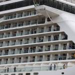 Passengers of the Norwegian Bliss look out across downtown Juneau as they wait to unboard Monday afternoon. (Clarise Larson / Juneau Empire)