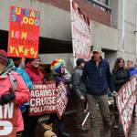Juneau residents hold signs in advocacy of more environmental regulation of the cruise industry as passengers unboard the Norwegian Bliss Monday afternoon. (Clarise Larson / Juneau Epire)