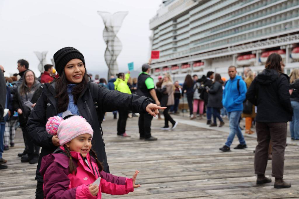 Carla Coronado and her four-year-old daughter Eva smile as the wait in line at one of the kiosks lined on Juneaus pier Monday afternoon. (Clarise Larson / Juneau Empire)
