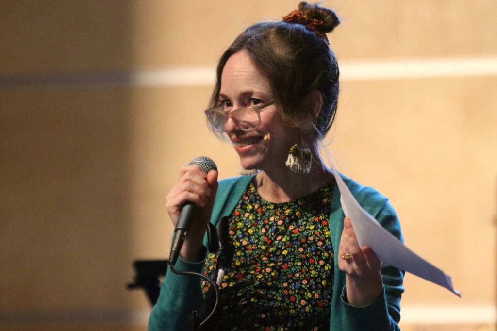 Mudrooms board member Summer Koester addresses housekeeping items as the evenings emcee on Tuesday night at Ḵunéix̱ Hídi Northern Light United Church for Mudrooms final event for the season. (Jonson Kuhn / Juneau Empire)