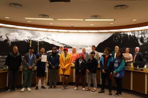 Clarise Larson / Juneau Empire 
From left to right, Minta Schwartz, Matthew Quinto, Kyle Khaayákw Worl, Ezra Elisoff, Leif Richards, Jordan Bennett, Lyric Ashenfelter, Sonny Mazon and Nathan Blake stand alongside City and Borough of Juneau Assembly members Monday night after being honored for their representation of Juneau for Team Alaska at the 2023 Arctic Winter Games.