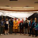 From left to right, Minta Schwartz, Matthew Quinto, Kyle Khaayákw Worl, Ezra Elisoff, Leif Richards, Jordan Bennett, Lyric Ashenfelter, Sonny Mazon and Nathan Blake stand alongside City and Borough of Juneau Assembly members Monday night after being honored for their representation of Juneau for Team Alaska at the 2023 Arctic Winter Games. (Clarise Larson / Juneau Empire)