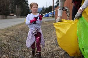 Catherine Berry, 6, places litter in a bag held open by her mother, Mary, during a communitywide cleanup held on Earth Day. The cleanup of public lands is an annual event organized by Litter Free Inc. (Ben Hohenstatt / Juneau Empire)