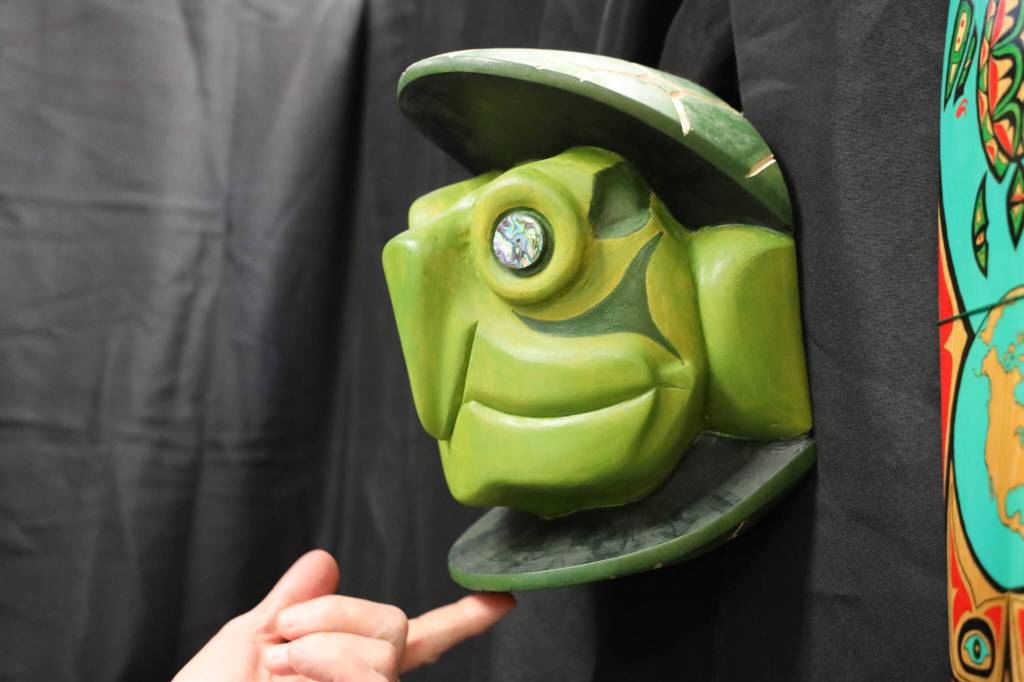 Kevin Jones, of the Choctaw Nation of Oklahoma, touches his turtle mask Luksi Sia that he carved. His piece was one of the many featured in a recent art gallery hosted Friday evening at the University of Alaska Southeast that showcased students work from the UAS Northwest Coast Art program. (Clarise Larson / Juneau Empire)