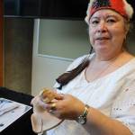 Tlingit artist Gáanax Sháa Gloria Eyon holds a Raven Rattle made from mountain ash that she began carving during a Sealaska Heritage Institute beginning carving class and continued at University of Alaska Southeasts intermediate carving class. The piece was one of the many featured in a recent art gallery hosted Friday evening at the University of Alaska Southeast that showcased students work from the UAS Northwest Coast Art program. (Clarise Larson / Juneau Empire)