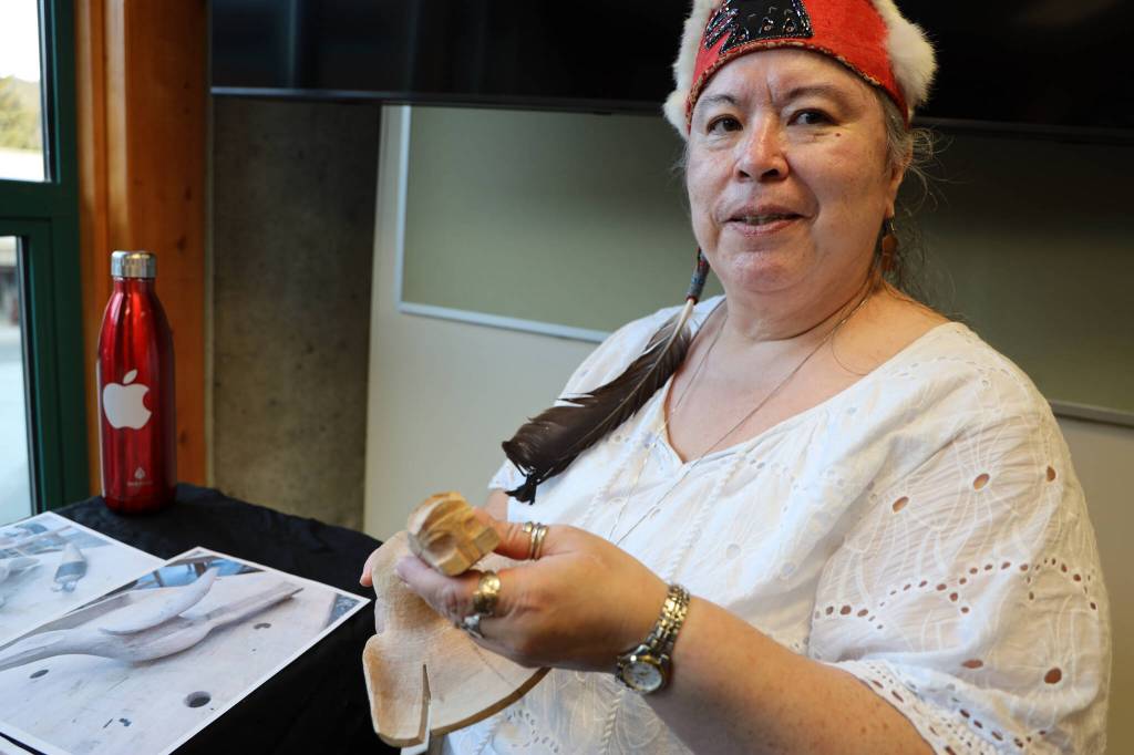 Tlingit artist Gáanax Sháa Gloria Eyon holds a Raven Rattle made from mountain ash that she began carving during a Sealaska Heritage Institute beginning carving class and continued at University of Alaska Southeasts intermediate carving class. The piece was one of the many featured in a recent art gallery hosted Friday evening at the University of Alaska Southeast that showcased students work from the UAS Northwest Coast Art program. (Clarise Larson / Juneau Empire)