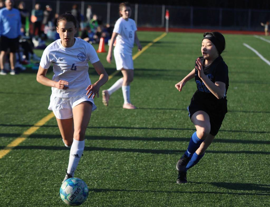 TMHS freshman Tuvy Vu (22) pursues Wheat Ridge Naomi Fireman Schiavoni (4) near the the Falcons goal line on Thursday for a non-conference game. Colorado visited Juneau for two non-conference games against both Juneau high schools. (Jonson Kuhn / Juneau Empire)