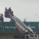 A Capital City Fire/Rescue truck bucket lowers Vance R. Webster III from the roof of Nugget Mall after being detained by Juneau Police Department Sunday morning. (Courtesy / Nano Brooks)