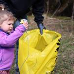 Genevieve Berry, 3, places litter in a trash bag on Earth Day during a communitywide cleanup. (Ben Hohenstatt / Juneau Empire)