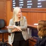 Rep. Andi Story, a Juneau Democrat, talks with a guest page on the House floor Wednesday morning. Story, a member of the House Education Committee, was among the members in the minority who expressed concern a bill giving teachers end-of-year bonuses will be used by House leaders to avoid a larger and more general increase to public school funding this session. (Mark Sabbatini / Juneau Empire)