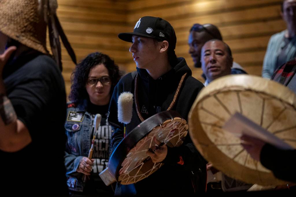 A welcome song is played and sang by Tulalip performers during a Road to Healing event at the Tulalip Gathering Hall in Marysville, Washington on Sunday, April 23, 2023. The tour is lead by United States Secretary of the Interior Deb Haaland and Department of the Interior Assistant Secretary Bryan Newland. (Annie Barker / The Herald)