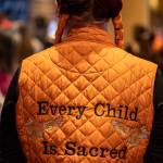 A person wears a vest that says Every Child Is Sacred during a Road to Healing event at the Tulalip Gathering Hall in Marysville, Washington on Sunday, April 23, 2023. The tour is lead by United States Secretary of the Interior Deb Haaland and Department of the Interior Assistant Secretary Bryan Newland. (Annie Barker / The Herald)