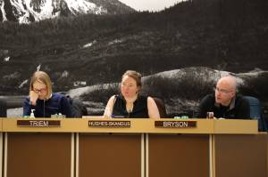 From left to right, City and Borough of Juneau Assembly members Carole Triem, Alicia Hughes-Skandijs and Wade Bryson listen to City Clerk Beth McEwen as she speaks about election code changes Monday night at the Assembly Committee of the Whole meeting where members OKd the city to move an ordinance to make vote-by-mail elections the default in Juneau. (Clarise Larson / Juneau Empire)