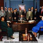 This photo held by the Alaska State Library shows the cabinet of Gov. Bill Sheffield. Seated in front of desk, left – Eleanor Andrews (Administration), right - Esther Wunnicke (Natural Resources). Standing – Marshall Lind (Education), Gary Hayden (Marine Highway System), Jim Robison (Labor), Roger Endell (Corrections), Emil Notti (Community & Regional Affairs), Gen. Edward Pagano (Adjutant Gen., Miltary & Veterans Affairs), Loren H. Lounsbury (Commerce & Econ. Dev.), Richard Knapp (DOTPF), Bill Ross (DEC), Don Collinsworth (F&G), John Pugh (H&SS), Hal Brown (Attorney General, Law), Robert Sundberg (Public Safety).  (Alaska Office of the Governor Photograph Collection, 1959 to present. ASL-PCA-213)