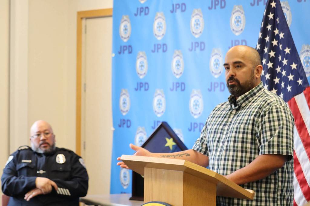 JPD Officer Nick Garza addresses the large crowd of attendees at Officer Kevin Fermins retirement ceremony of Friday to share heart-warming stories of his time served in the department during Fermins 25 years of service. (Jonson Kuhn / Juneau Empire)